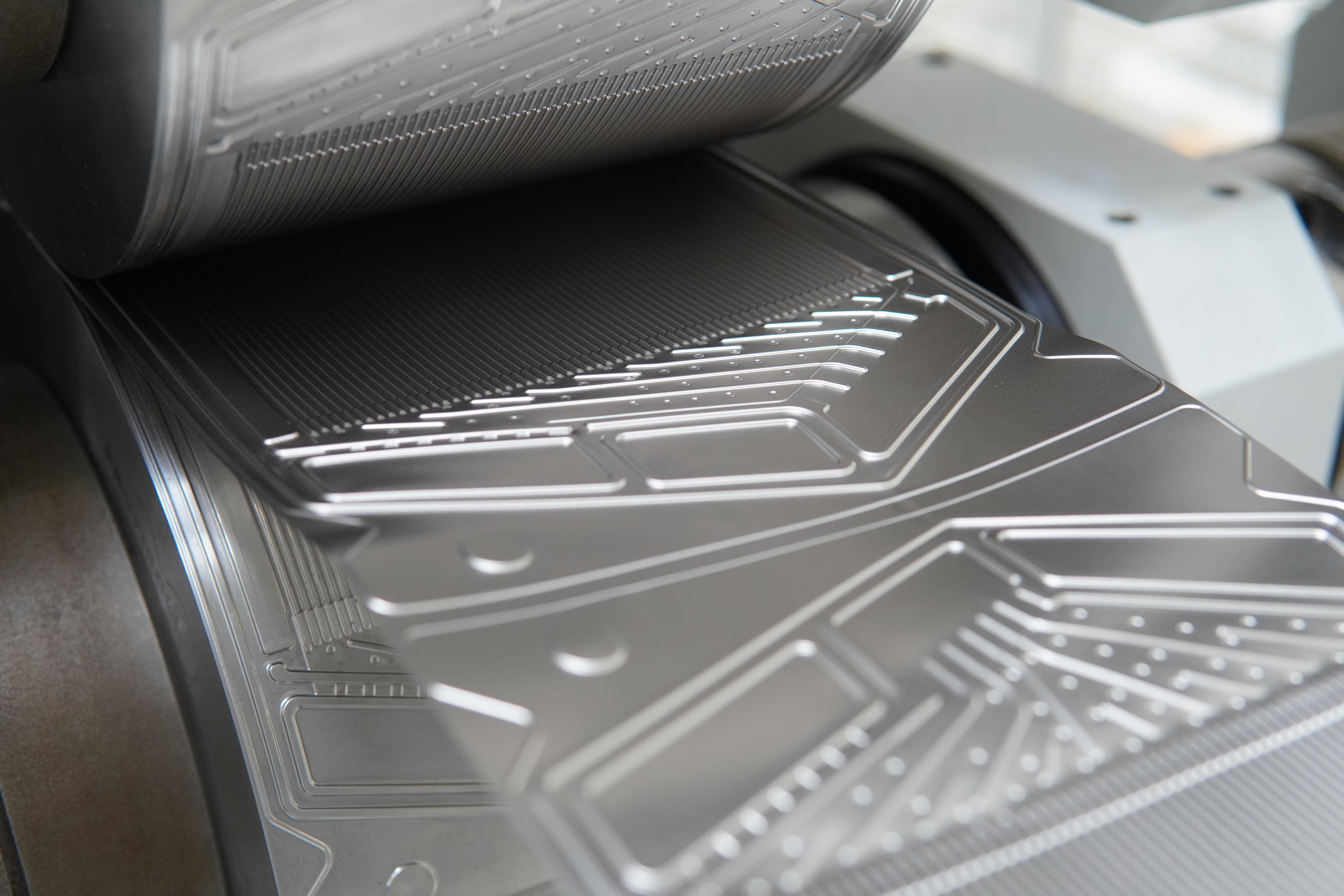 Roll pair with punch and die roll: the metal strip runs through continuously.